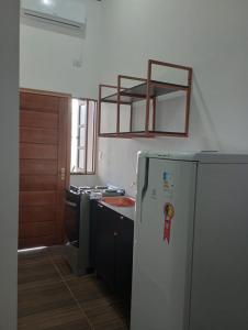 卡纳内亚Cantinho do Sossego - kitnets的厨房配有白色冰箱和水槽