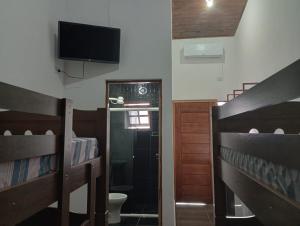 卡纳内亚Cantinho do Sossego - kitnets的客房设有两张双层床和一台平面电视。