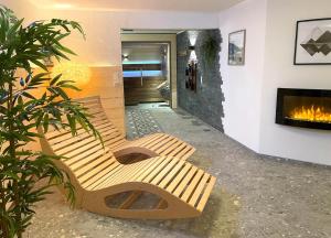 上迈塞尔施泰因Landhaus Obermaiselstein "THE VIEW"的带壁炉的客房内设有两张木长椅