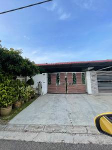 巴西古当three bedroom tarraced house - RainaHomestay Pasir Gudang的一个带门车库的房子