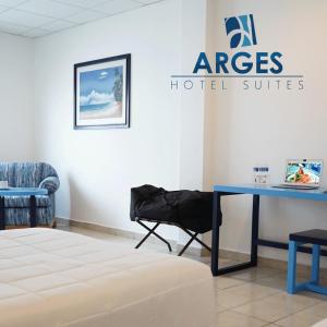 切图马尔Hotel & Suites Arges - Centro Chetumal的一间设有蓝色桌子的客房和酒店套房标志