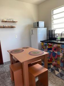 弗洛里亚诺波利斯Apartamento encantador cachoeira的厨房配有木桌和冰箱。