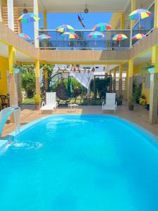 马拉戈日Pousada O Sol De Maragogi的度假村内带遮阳伞的大型游泳池