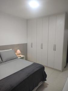 巴西利亚Studio In - Apt° 205 com Garagem的一间卧室配有一张床和白色橱柜