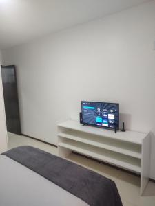 巴西利亚Studio In - Apt° 205 com Garagem的一间客厅,在白色的橱柜上配有电视