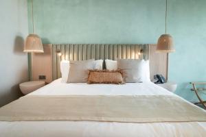 圣安德烈斯Nattivo Collection Hotel的一间卧室配有一张带两盏灯的大型白色床。