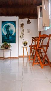 阿拉亚尔达茹达Hostel Aconchego do Arraial的一间房间,配有椅子和墙上的绘画作品