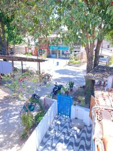 阿拉亚尔达茹达Hostel Aconchego do Arraial的一个带蓝色栅栏和树的花园