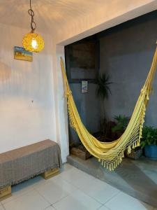 阿拉亚尔达茹达Hostel Aconchego do Arraial的一张黄色的吊床挂在一张床的房间
