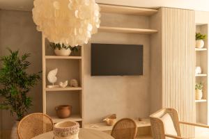 圣安德烈斯Nattivo Collection Hotel的客厅配有电视和桌椅
