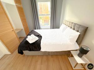 莫珀斯Modern 1 Bed Apartment In Morpeth Town Centre的一间卧室配有一张带白色床单的床和一扇窗户。