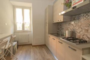 钱皮诺[ROME 15min]Modern Accommodation, Airport,Station,LinkHouseCiampino的厨房配有白色橱柜和炉灶烤箱。