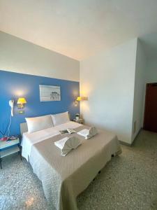 里米尼Hotel Alfa ALL INCLUSIVE 2024的一间卧室设有一张蓝色墙壁的大床