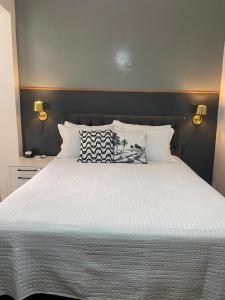 里约热内卢Studio Copacabana的卧室配有一张带两个灯的大白色床