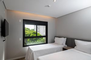 圣保罗EZ Moema Hotel的带窗户的客房内的两张床