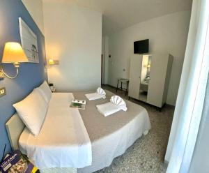 里米尼Hotel Alfa ALL INCLUSIVE 2024的酒店客房,配有带两条毛巾的床