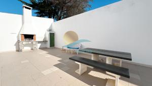 阿尔布费拉Villa Bea by Sunny Deluxe的庭院设有长凳和壁炉。