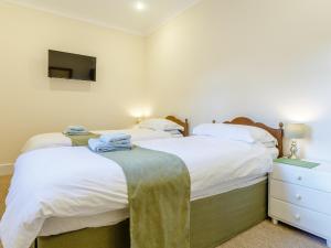 Black Torrington2 Bed in Holsworthy 77555的卧室设有两张床,墙上配有电视。