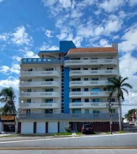 博卡德尔里奥"Condominio Américas"的一座高大的白色建筑,前面有棕榈树