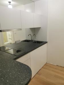 贝尔格莱德BG Exclusive Apartment的厨房配有白色橱柜和黑色台面
