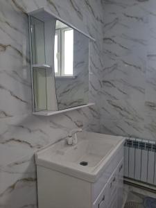 卡拉科尔GuestHouse "ERKIN"的白色的浴室设有水槽和镜子