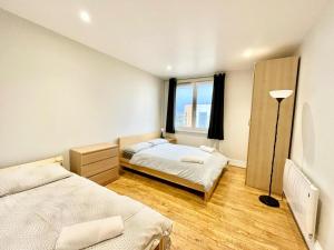 伦敦London Modern Flat near transports的一间卧室设有两张床和窗户。