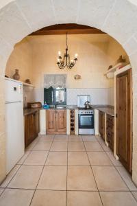 纳杜尔3 Bedroom Farmhouse with Private Pool & Views in Nadur Gozo的厨房配有白色冰箱和木制橱柜。