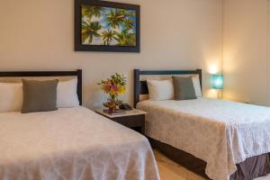 坎昆帕尔梅拉斯酒店的卧室内两张并排的床