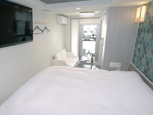 东京Hotel Opera的卧室配有一张白色大床和一把椅子