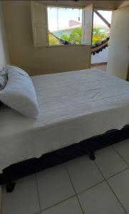 马拉戈日Pousada Esmeralda的配有枕头和窗户的客房内的一张床位