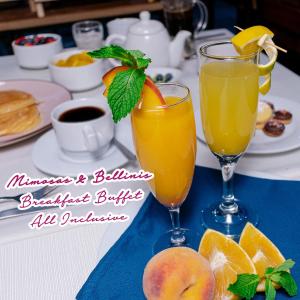 库斯科Union Hotel Cusco的桌上的两杯橙汁和水果