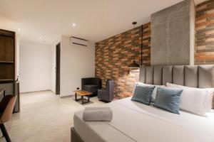 麦德林Apartahotel Medellin的一间卧室设有一张大床和砖墙
