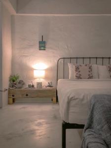 乌汶德亮旅馆的一间卧室配有一张床和一张带台灯的桌子