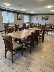 密尔沃基密尔沃基机场速8酒店的用餐室配有大型木桌和椅子