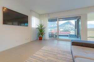 卢加诺IMPERIAL of LUGANO apartment-behind the station with FREE parking的带沙发和大窗户的客厅