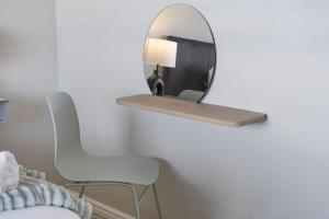 布鲁堡史特兰Witsand 102 by HostAgents的墙上的镜子,带椅子和灯