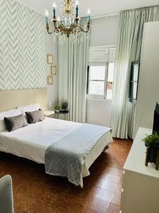 大加那利岛拉斯帕尔马斯Arrebol Vegueta的一间卧室配有一张床和一个吊灯