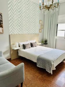 大加那利岛拉斯帕尔马斯Arrebol Vegueta的一间卧室配有一张大床和一个吊灯。