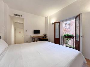 卡利亚里Al Duomo di Cagliari的卧室设有一张白色大床和一扇窗户。