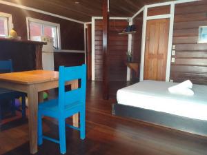 博卡斯德尔托罗Casa elba sobre el mar的一间卧室配有桌子、一张床和一张蓝色椅子