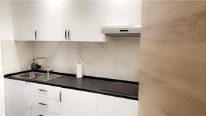 布鲁塞尔Calme, agréable et fonctionnel的白色的厨房配有水槽和白色橱柜