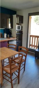 安格勒Bel appartement avec balcon的厨房配有木桌、两把椅子和一张桌子