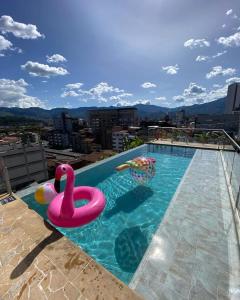 麦德林Apartahotel Medellin的一个带粉红色天鹅和球的游泳池