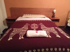 帕帕亚克塔La Quiteñita Papallacta的一张床上,上面印有两条长颈鹿,铺在毯子上