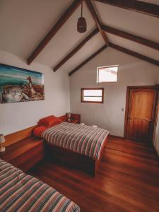 Isla de SolEcolodge Santo Campo的一间卧室设有两张床,墙上挂着一幅画