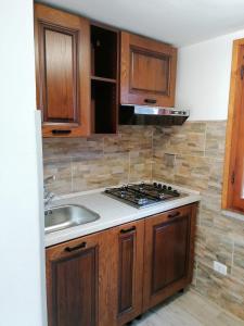 坎普码头Appartamento Scirocco的厨房配有水槽和炉灶 顶部烤箱