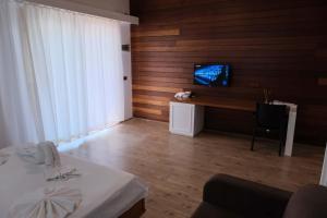 契拉勒Apella Hotel的一间卧室配有一张床,墙上配有电视
