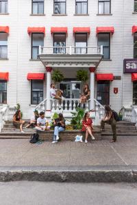 蒙特利尔Auberge Saintlo Montréal Hostel的一群人坐在建筑物的台阶上