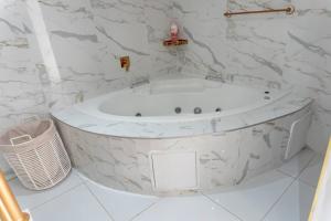 比勒陀利亚Homes of Ace Diamond的浴室设有白色浴缸,拥有大理石墙壁。