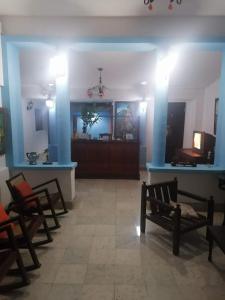 格拉纳达HotelCasaMorazanGranadaNicaragua的一间带椅子的房间和一间蓝色墙壁的房间